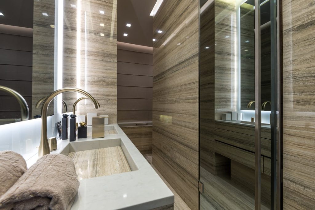 A contemporary bathroom featuring sleek marble surfaces, elegant fixtures, and ambient lighting.